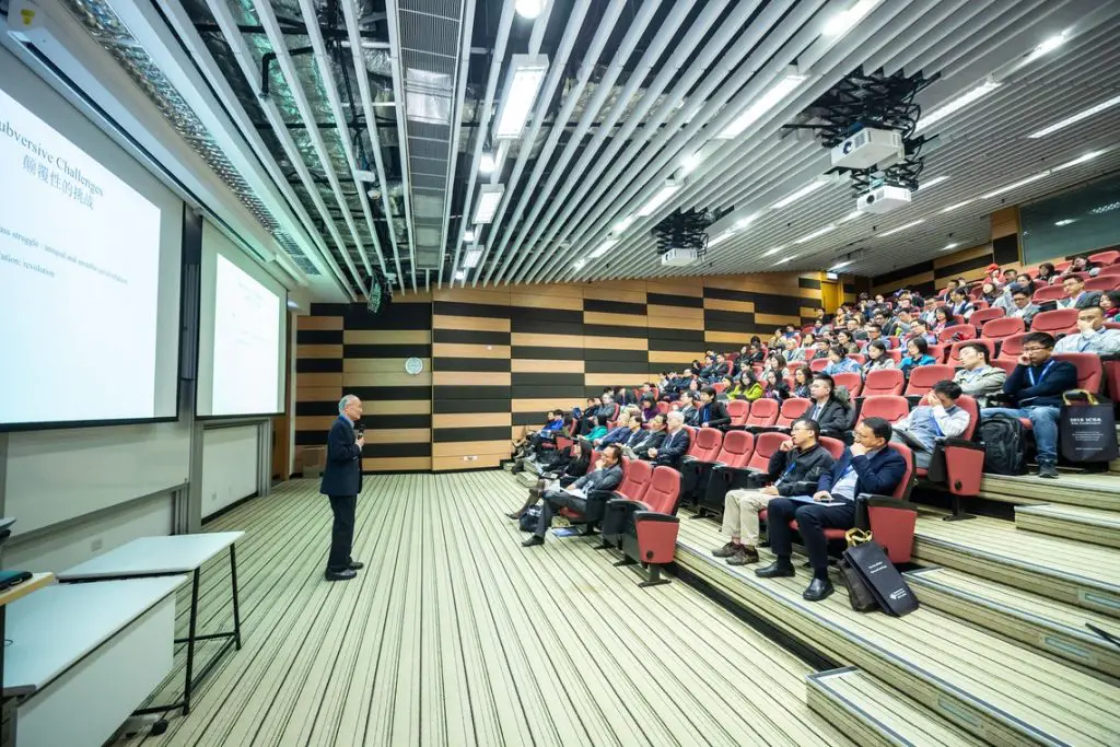 A man standing in front of a large room full of people