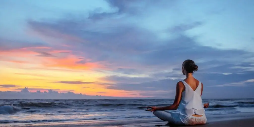 A woman meditating on the beach 