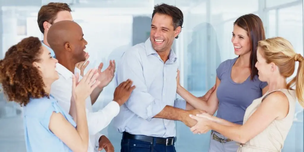 a business team applauding their successful project leader. Examples of interpersonal skills