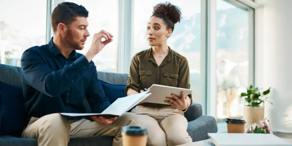 cropped shot of two young businesspeople having meeting in the break room