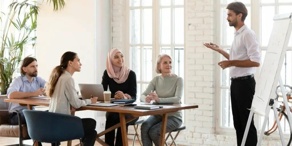 Confident businessman coach trainer speaker gives flip chart presentation.