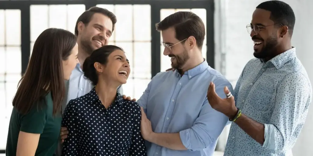 Happy Coworkers Congratulating Excited Indian Female Employee