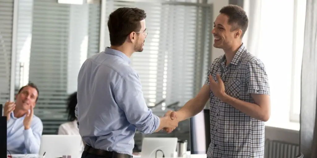 Ceo motivating rewarding male employee shaking hand congratulating with promotion