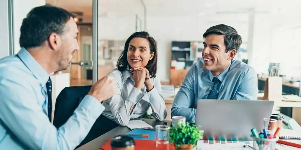 a small group of business persons talking in the office