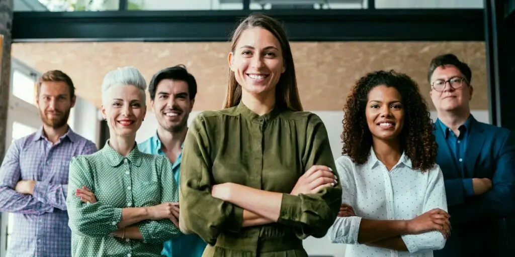 Shot of beautiful confident smiling businesswoman standing in front of her successful team 