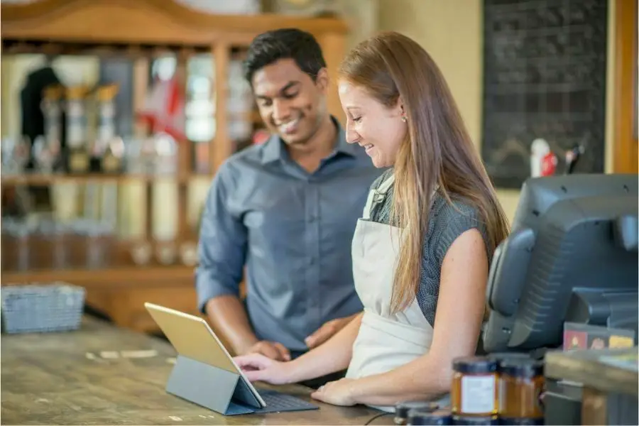 A barista and cafe owner are standing together at the restaurant's counter. Online Ordering at a Local Cafe