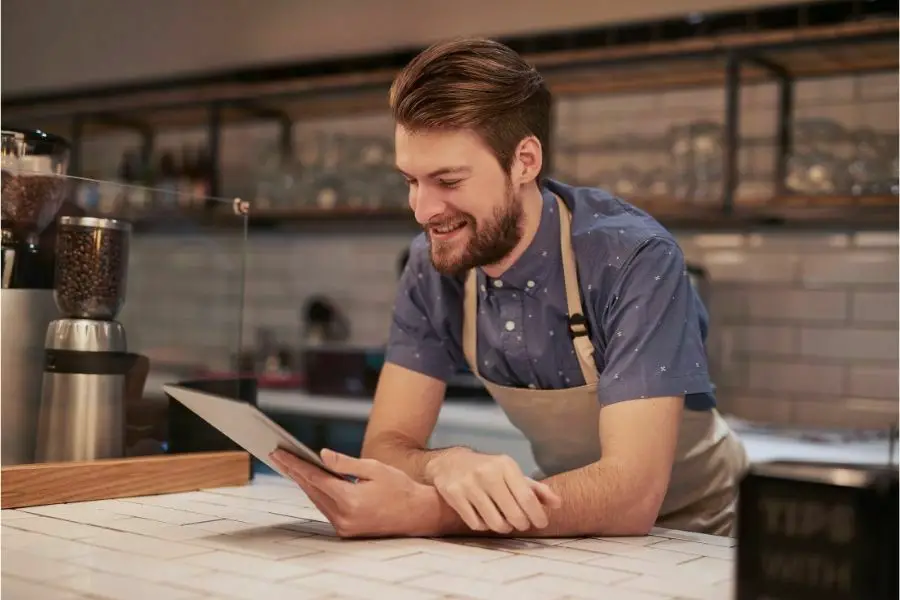 Shot of a young man using a digital tablet while working in a coffee shop. local online marketing