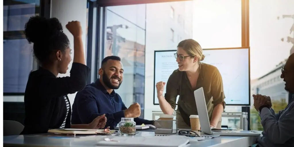 Shot of a team of young businesspeople cheering during a meeting in the evening at work