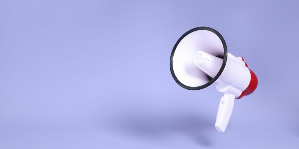 The isolated picture of a megaphone floating on the purple background