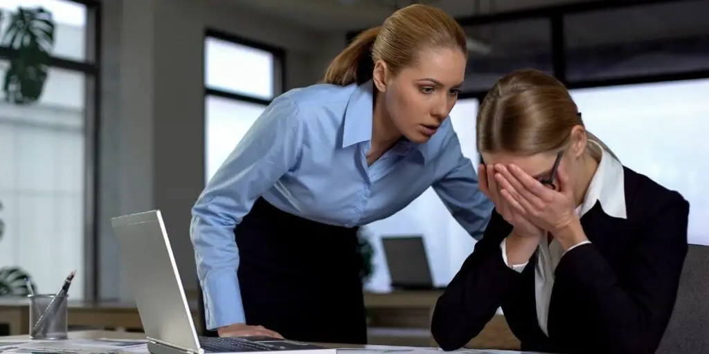 Boss shouting at a frustrated employee. Causes of Low Company Morale