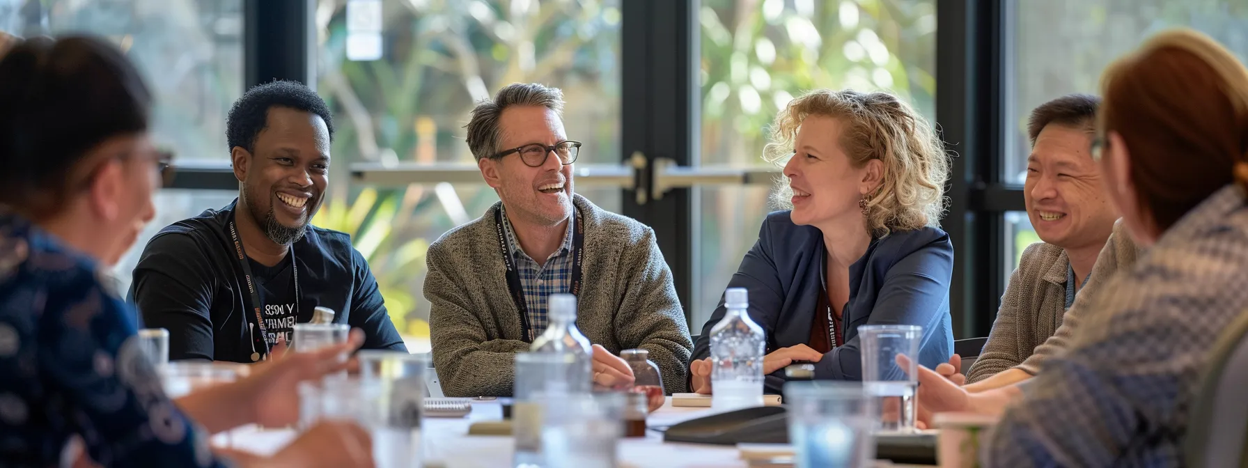 a group of diverse professionals engaged in a lively discussion, exchanging smiles and gestures of understanding, showcasing the positive impact of mastering feedback on communication outcomes.