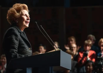 a determined margaret thatcher stands confidently at a podium, surrounded by cheering supporters, ready to take on the world.