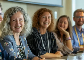 a diverse group of smiling colleagues gathered around a conference table, engaged in lively discussion and sharing ideas.