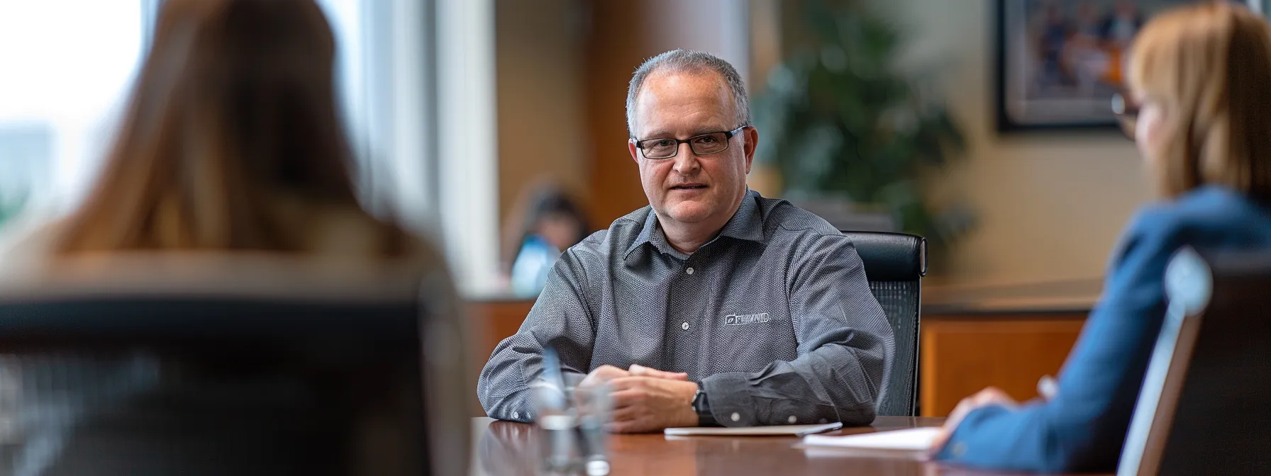 a focused employee sitting attentively at a conference table, actively engaging with company policies and procedures during an internal investigation process.