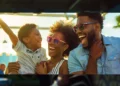 a family laughing and high-fiving as they tee off at topgolf on a sunny day.