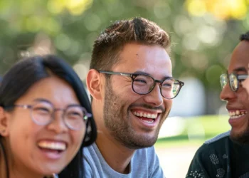 a diverse group of coworkers smiling and bonding during a team-building exercise in a sunny park.