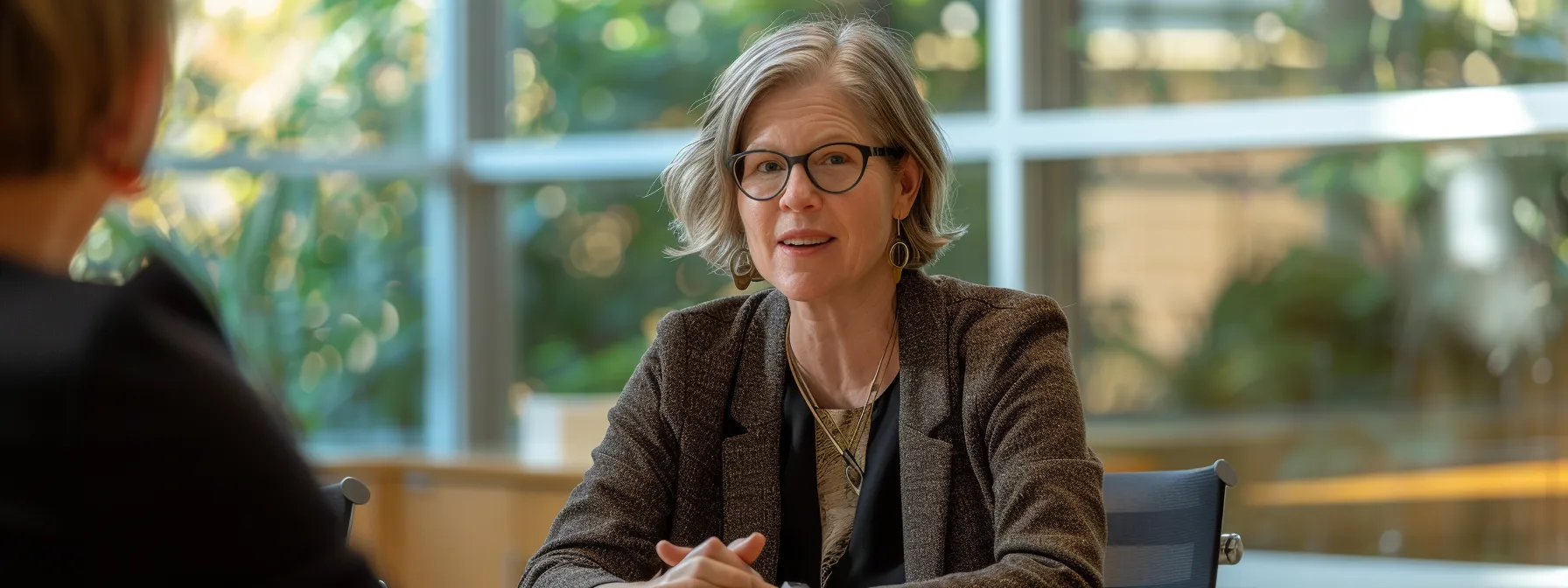 a leader sitting at a conference table, engaging in open and transparent communication with their team, demonstrating consistency and empathy as they discuss shared goals and responsibilities.