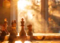 a strategic chessboard set up under a beam of golden sunlight.