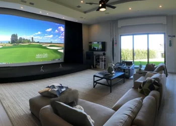 a sleek, modern home golf simulator setup in a spacious living room, complete with a large projection screen and high-tech sensors.